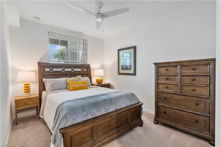 Bedroom with light colored carpet and ceiling fan