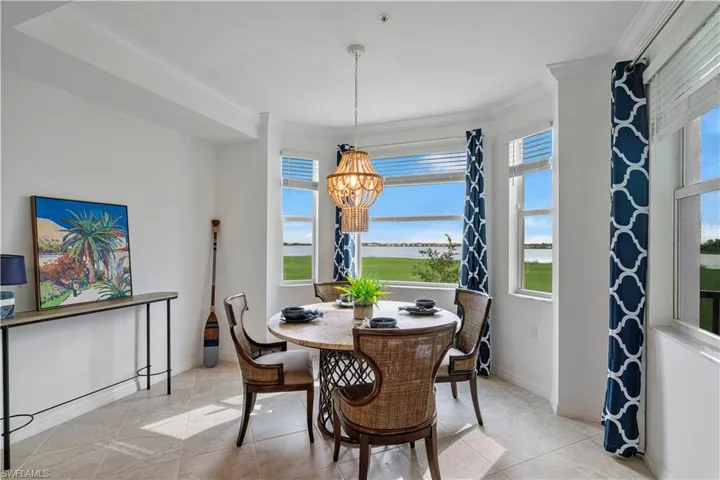 Dining space with a notable chandelier, a wealth of natural light, and light tile patterned floors