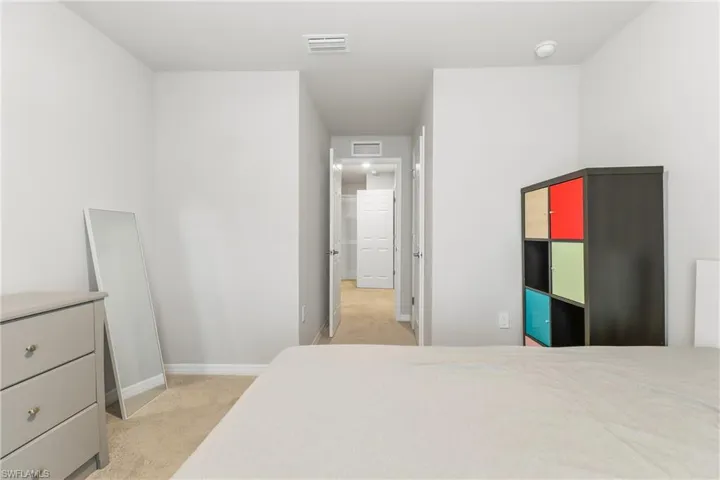 Bedroom featuring light carpet