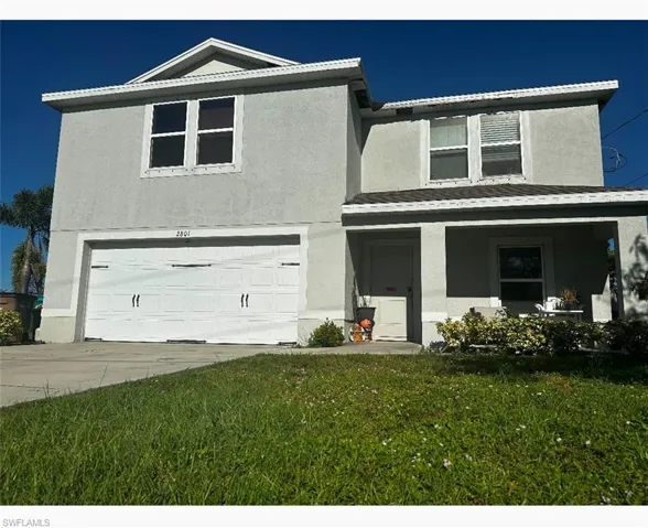 View of front of home with a front lawn and a garage