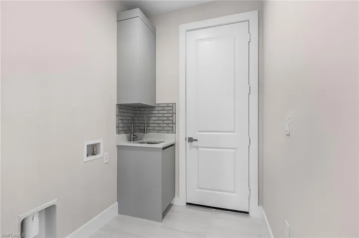 Washroom featuring baseboards and hookup for a washing machine