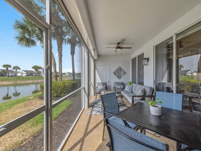 Sunroom with a water view, an outdoor living space, and ceiling fan