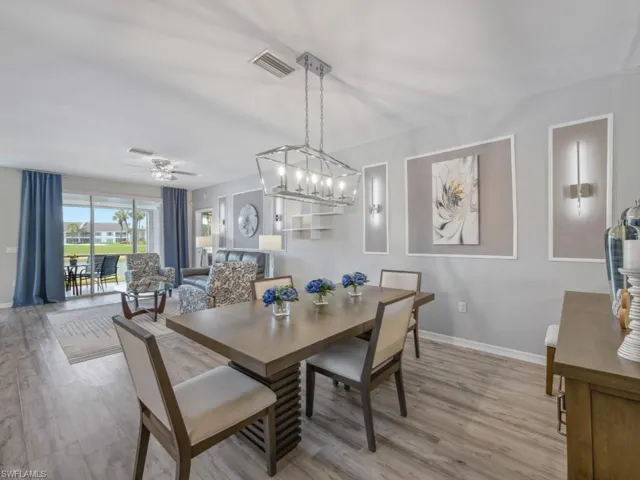 Dining room featuring baseboards, visible vents, ceiling fan with notable chandelier, and wood finished floors