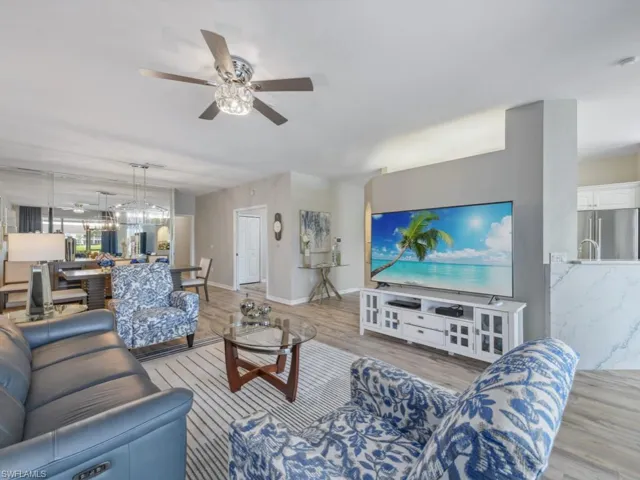 Living area with baseboards, a ceiling fan, and light wood finished floors