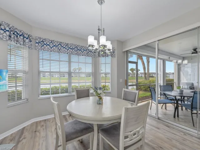Dining room with light wood-style flooring, ceiling fan with notable chandelier, and baseboards