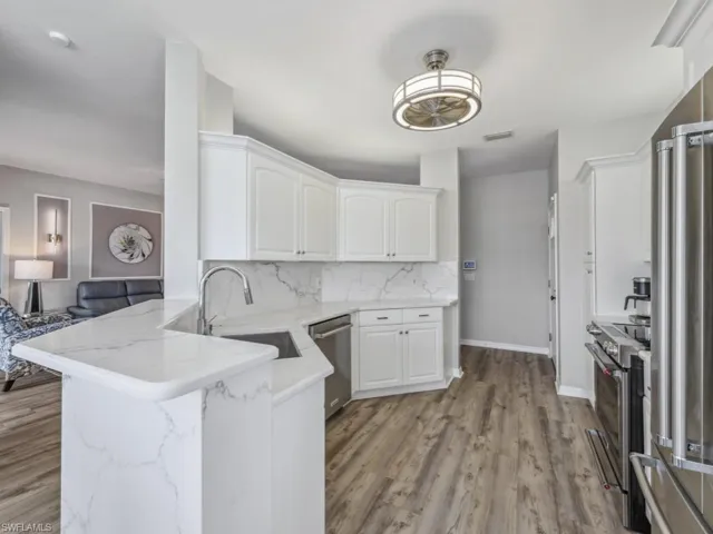 Kitchen featuring white cabinetry, a sink, stainless steel appliances, and backsplash