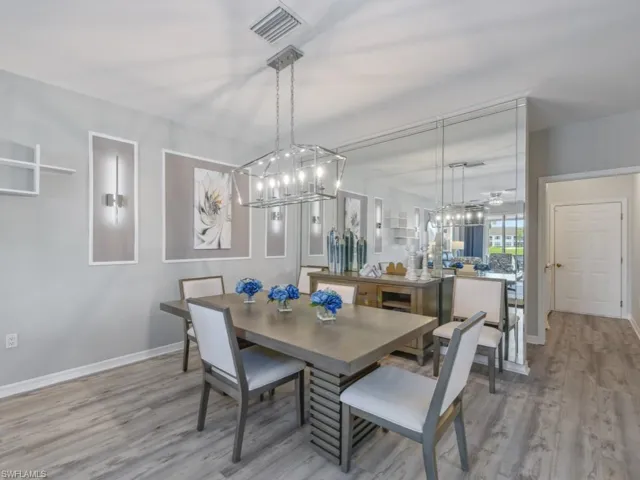 Dining space featuring baseboards, visible vents, an inviting chandelier, and light wood-style floors