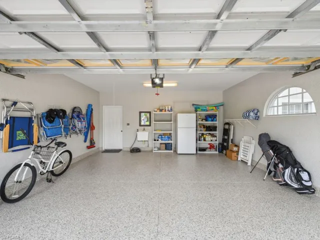 Garage with a garage door opener and freestanding refrigerator