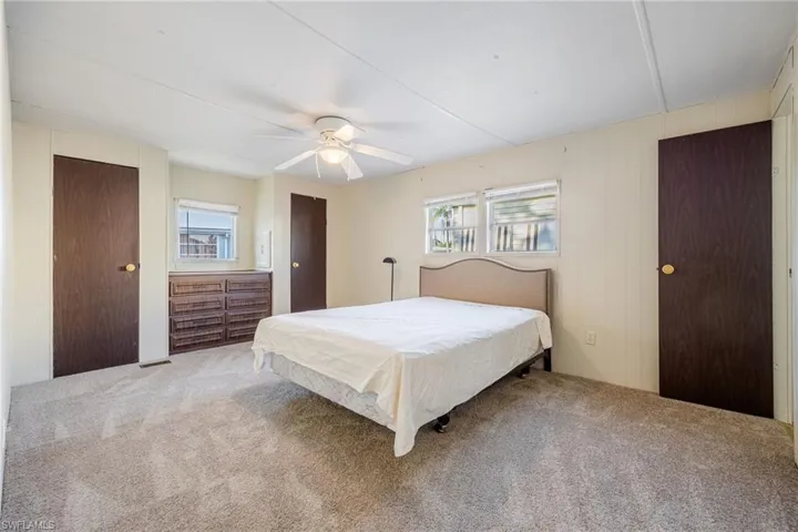 Bedroom featuring carpet flooring, multiple windows, and ceiling fan
