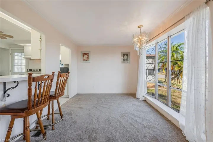 Dining space featuring crown molding, an chandelier, and new carpet