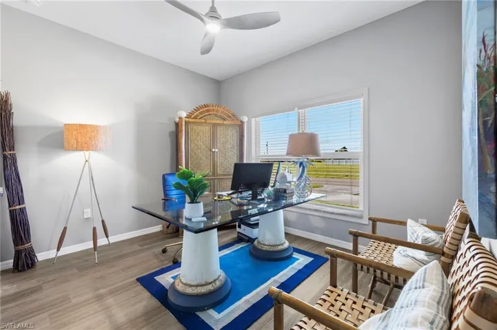 Office area with wood finished floors and ceiling fan