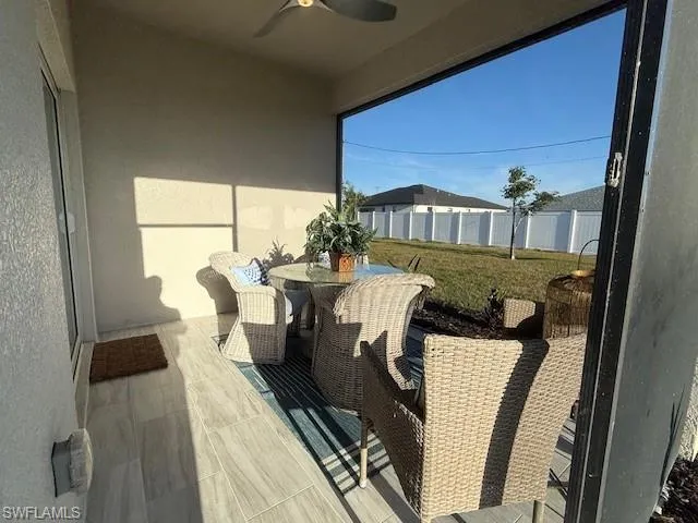 Balcony featuring outdoor dining space and ceiling fan