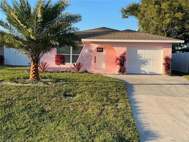 Single story home with an attached garage, driveway, stucco siding, and a shingled roof