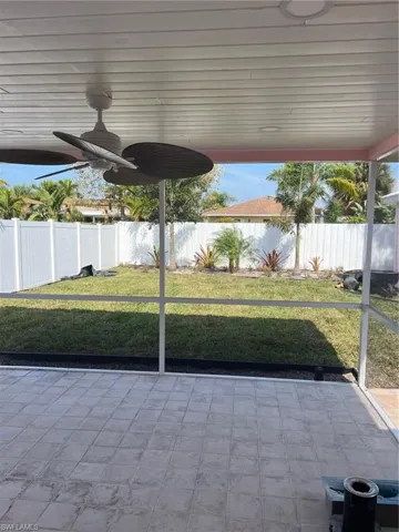 Fenced backyard with a ceiling fan
