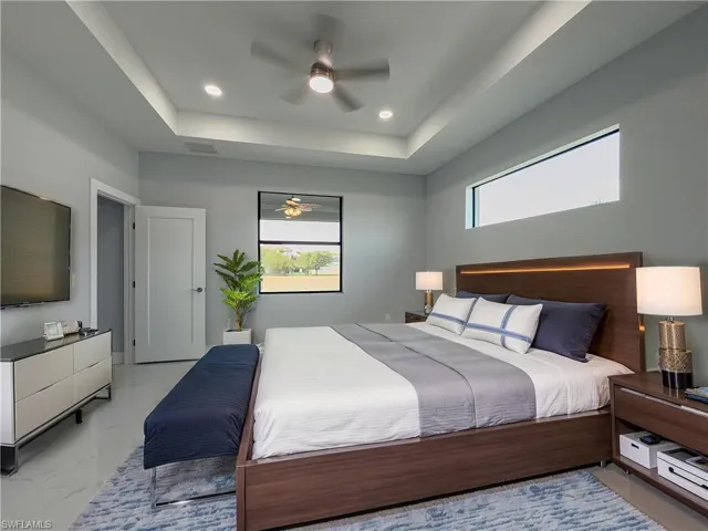 Bedroom with a ceiling fan, visible vents, marble finish floor, a tray ceiling, and recessed lighting