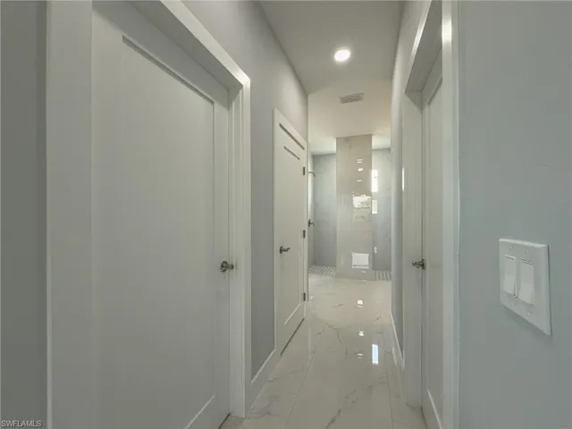 Hall featuring marble finish floor, visible vents, and baseboards
