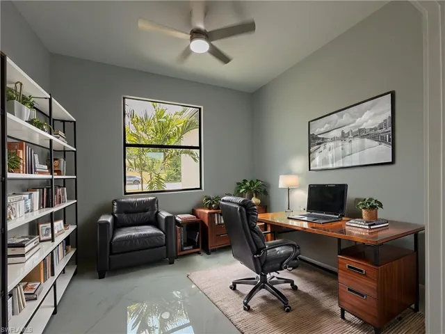 Office space with a ceiling fan and marble finish floor