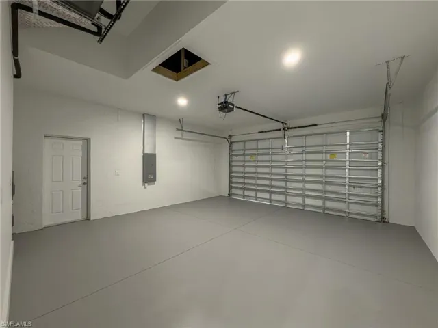 Garage with electric panel and a garage door opener