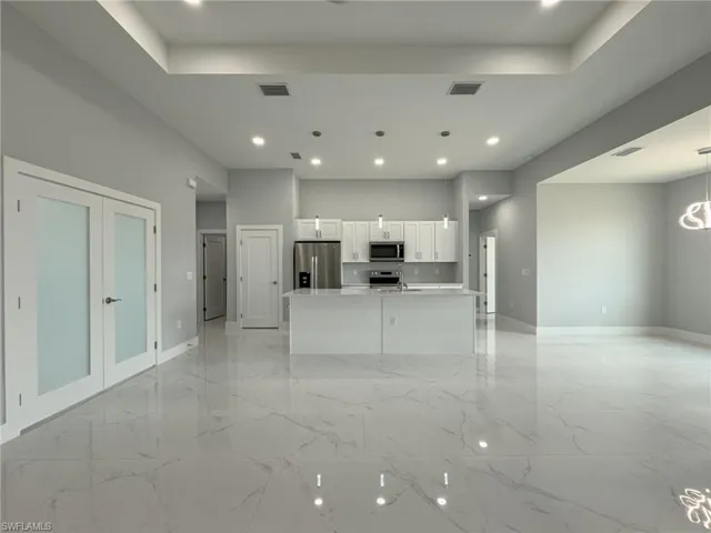 Unfurnished living room with baseboards, visible vents, and recessed lighting