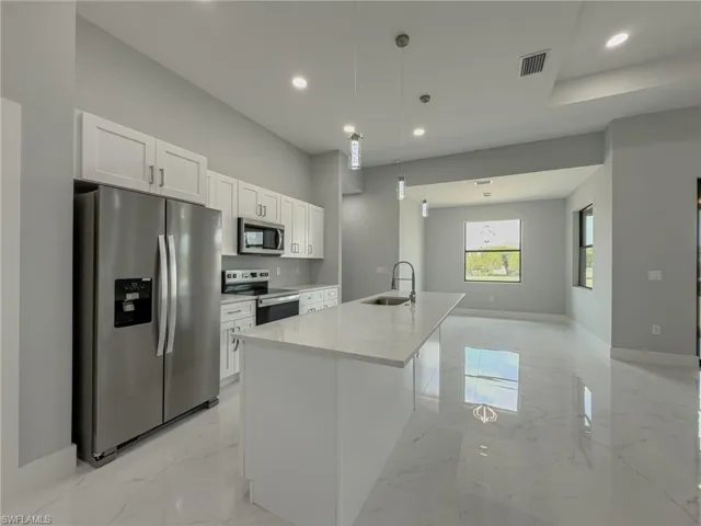 Kitchen featuring white cabinets, a sink, visible vents, stainless steel appliances, and marble finish floor
