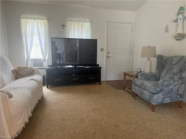 Living room with carpet flooring and cooling unit