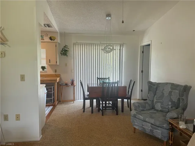 Dining room featuring carpet and a textured ceiling