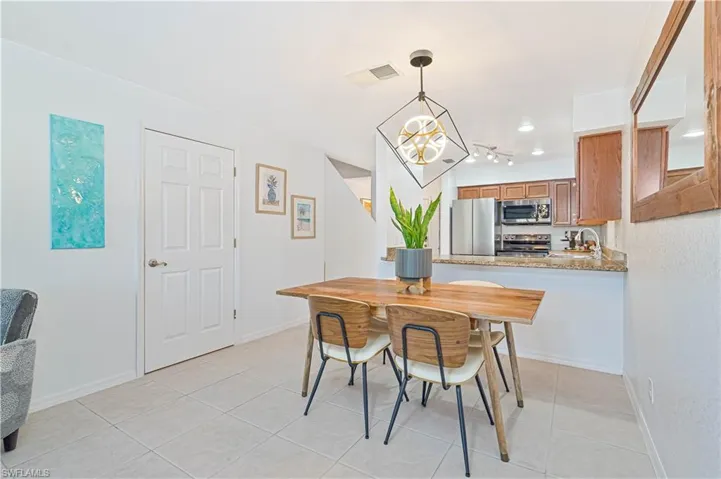 Dining room featuring light tile patterned floors, an inviting chandelier, and sink