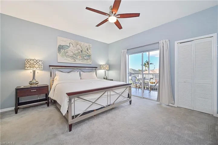 Carpeted bedroom with access to outside, a closet, and ceiling fan