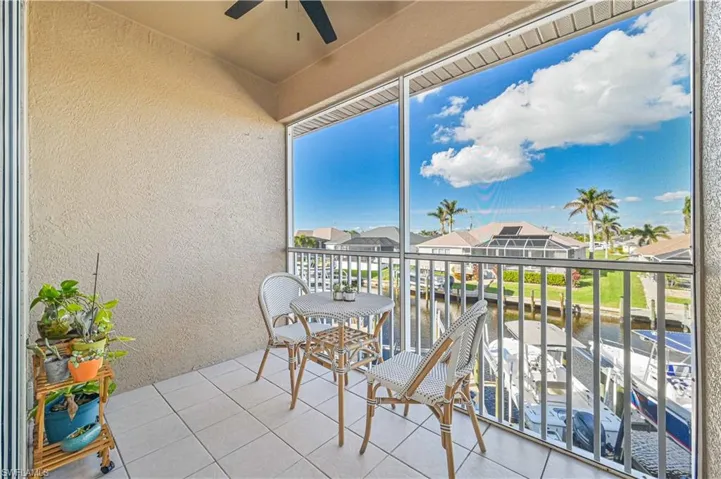 Sunroom featuring a water view and ceiling fan