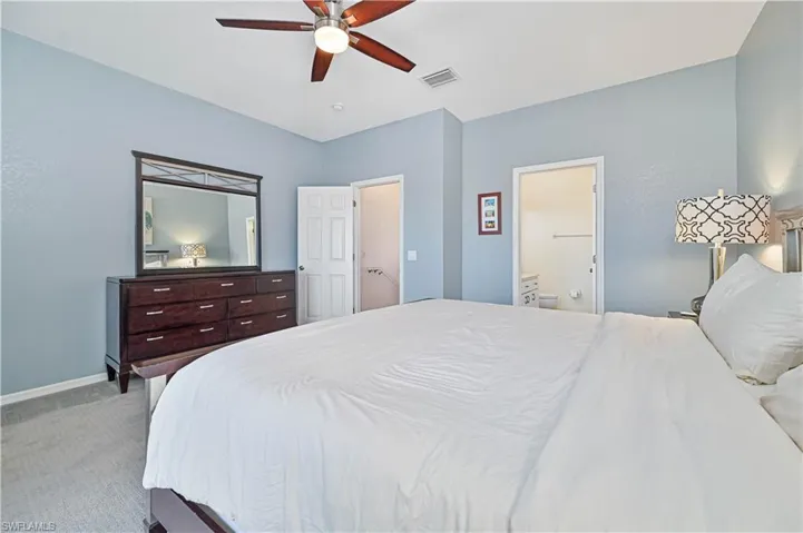Bedroom featuring ceiling fan, carpet floors, and connected bathroom