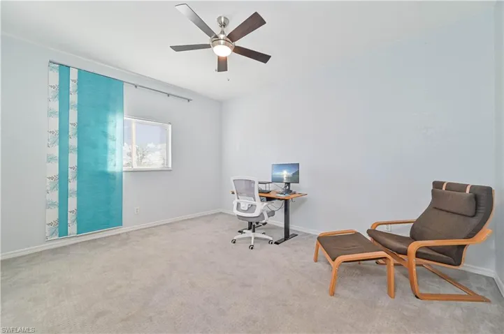 Office area with light carpet and ceiling fan