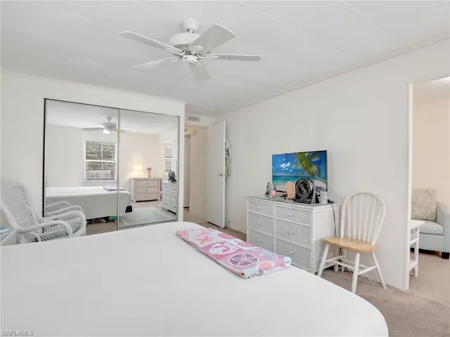 Carpeted bedroom with a closet and ceiling fan