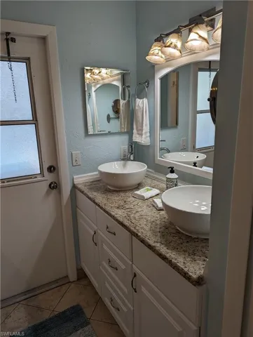 Bathroom featuring double vanity and tile patterned flooring