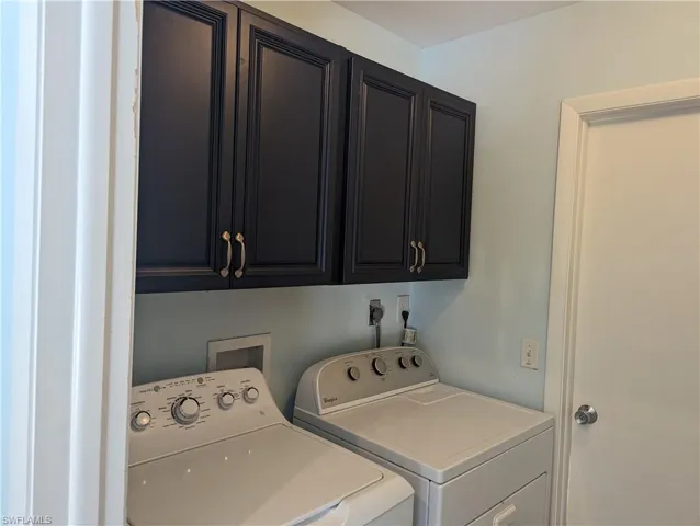 Laundry area featuring independent washer and dryer and cabinet space