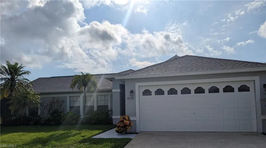 Ranch-style house with concrete driveway, stucco siding, a shingled roof, and a garage