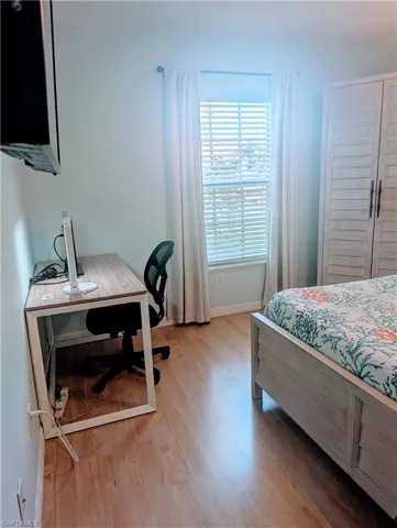 Bedroom featuring an office area with desk, monitor, and comfortable chair.