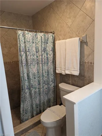 Bathroom featuring a tile shower and tile patterned flooring