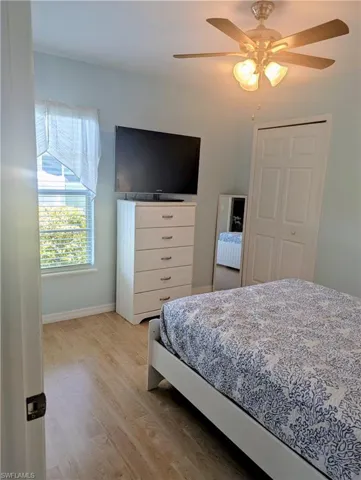 Bedroom Queen bed, night stand, full length mirror, TV and a ceiling fan