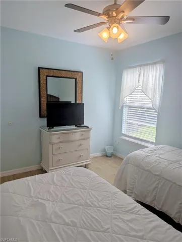 Bedroom featuring TV, dresser, and mirror.