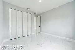 Unfurnished bedroom with a closet and light tile floors