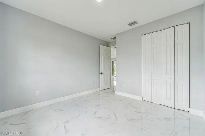 Unfurnished bedroom featuring a closet and light tile flooring