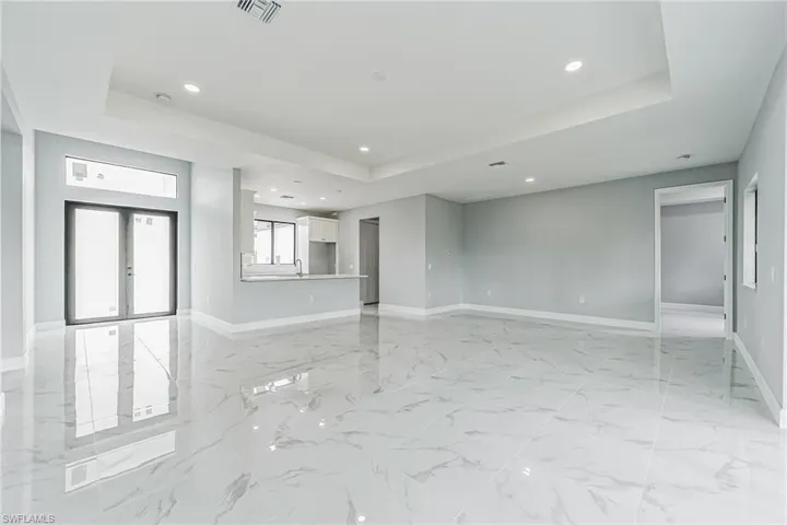 Tiled spare room featuring sink, french doors, and a raised ceiling