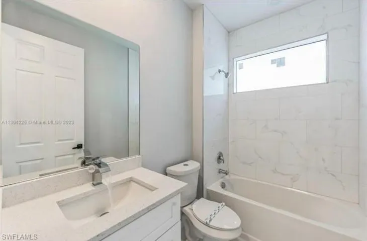 Tiled empty room featuring a raised ceiling