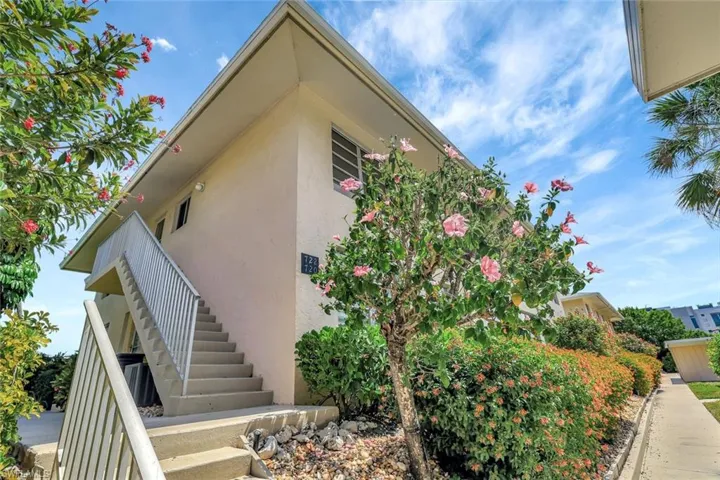 View of property exterior featuring stairway and stucco siding