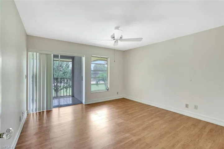 Unfurnished room with wood finished floors, baseboards, and ceiling fan
