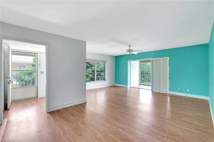 Spare room featuring plenty of natural light, light wood-type flooring, and baseboards