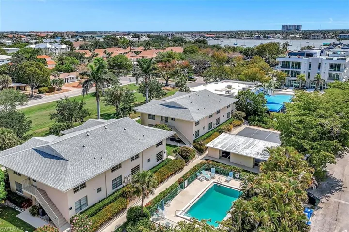 Bird's eye view of a pool area and a nearby body of water