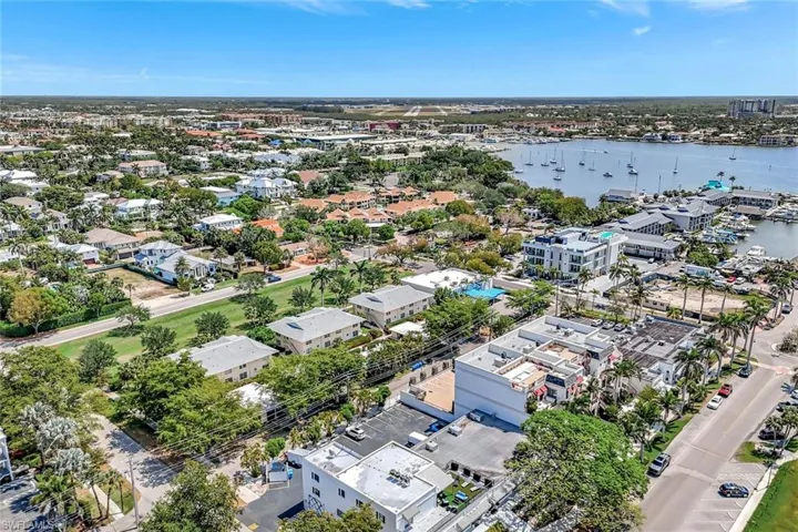 Drone / aerial view of a large body of water; Villa Versailles are the 3 buildings, 2 stories in the middle of the photo.