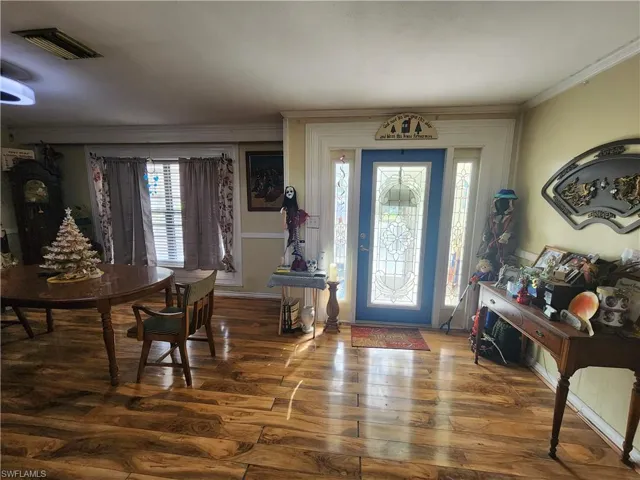 Entrance foyer featuring ornamental molding and wood finished floors