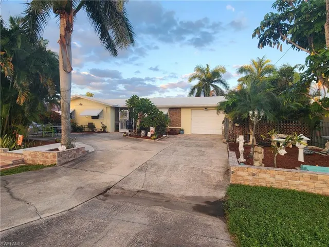 View of front facade with concrete driveway, stucco siding, and a garage